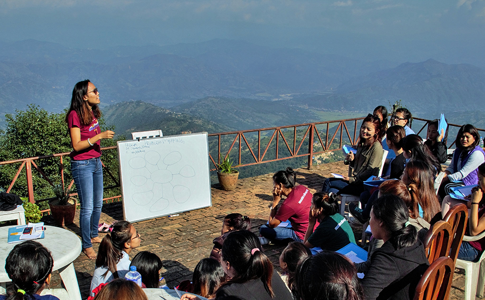 Tsechu Dolma (standing) at a community meeting in Nepal